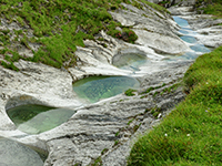 Einige der wie eine Perlekette angeordneten Gletschermühlen oberhalb Trin bei der Alp Mora